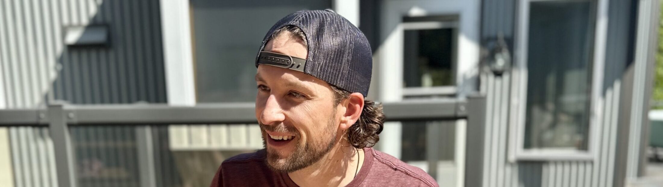 Scott German smiling outdoors in a backwards cap
